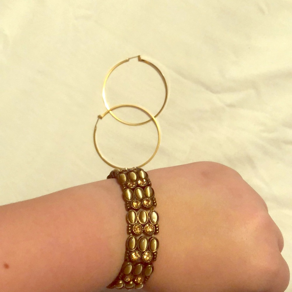 A gold bracelet and gold hoop earrings